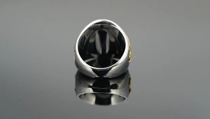 Detailed macro view of heavy vintage Masonic titanium ring with two-tone silver and gold texture
