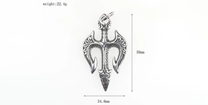 Macro detail of vintage steel trident pendant with scroll patterns and measurements