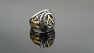 Macro detail of Masonic ring showing dual-tone steel finish and G emblem engraving