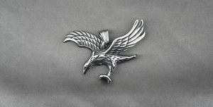Macro detail of vintage eagle pendant showing feather texture and S.Steel hallmark