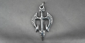 Detailed macro view of vintage trident pendant with intricate relief scroll patterns