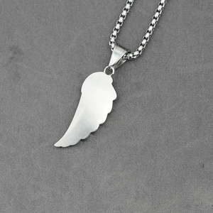 Polished silver feather pendant with box chain on grey fabric, minimalist jewelry accessory