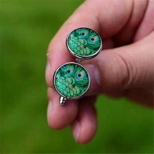 Silver mens cufflinks with peacock feather glass dome patterns in natural outdoor light