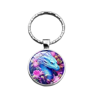 Detailed close-up of a silver dragon keychain with blue dragon and floral illustration