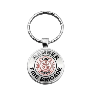 Detail of silver metal firefighter keychain featuring red Maltese cross and fire rescue text