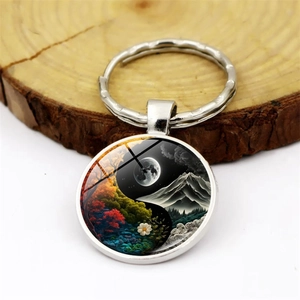 Macro detail of yin yang tree of life metal keychain with decorative glass pendant