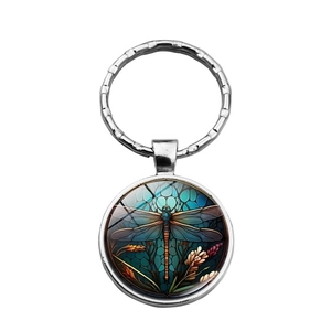 Detail of dragonfly glass cabochon keychain with blue honeycomb artistic pattern