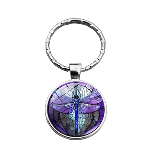 Detail of dragonfly keychain showing purple stained glass patterns on a silver round pendant