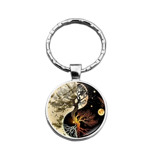 Close-up of Yin Yang Tree of Life glass cabochon pendant on a silver metal keychain ring