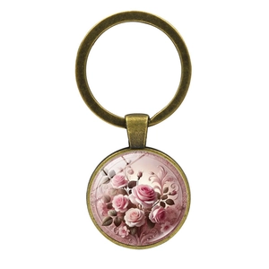 Vintage bronze keychain with a pink rose floral pattern glass dome on a white background