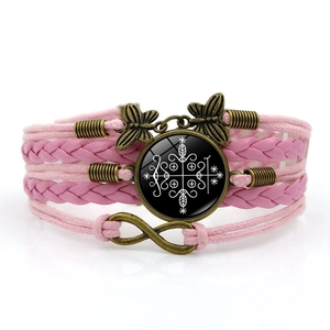 Detail eines rosa mehrlagigen Armbands mit Schmetterling, Unendlichkeitssymbol und Mystik