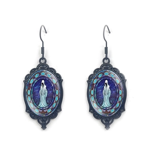 Macro detail of Gothic oval drop earrings featuring a hooded phantom figure and blue-purple glass