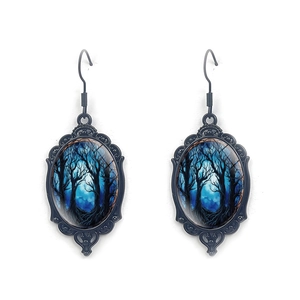 Macro detail of Gothic oval drop earrings with black frame and moonlit forest scene