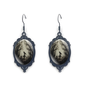 Detail of gothic oval earrings featuring a dark crow and cross design on black alloy