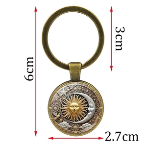 Vintage bronze sun and moon keychain with star and cloud charms on a white background