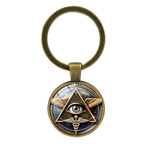 Detailed close-up of retro brass Eye of Horus keychain with Caduceus wing symbol