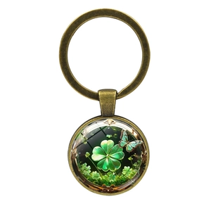 Vintage bronze keychain with four-leaf clover and butterfly glass pendant on white background