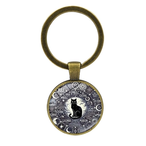 Porte-clés en bronze avec chat noir et roue de l'année sur fond blanc immaculé
