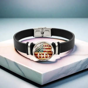 Détail du bracelet en cuir Route 66 avec motif drapeau USA sur fond de marbre blanc