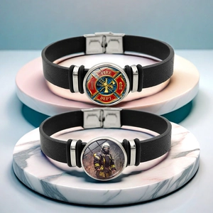 Gros plan détaillé de deux bracelets emblème de pompier sur des supports en marbre