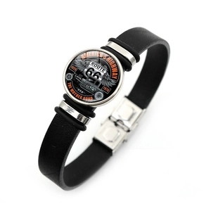 Détail du pendentif Route 66 en verre et de la texture en cuir noir tressé sur le bracelet