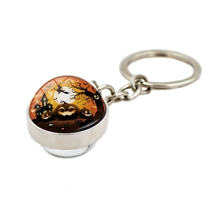Detail of Halloween keychain with round glass pendant featuring a pumpkin and wizard design