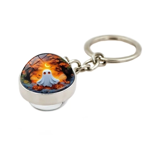 Detail view of Halloween keychain with ghost and glowing pumpkin in crystal glass dome