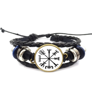 Detail of multi-layer leather bracelet with Nordic Viking compass and woven cords