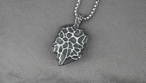 Detailed close-up of retro titanium steel evil eye pendant with hammered texture for men