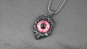 Macro shot of Gothic punk devil eye pendant with hammered texture and S. Steel engraving
