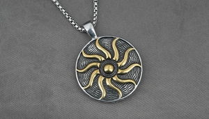 Macro shot of two-tone titanium sunflower pendant with vintage sun totem and box chain