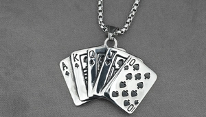 Detailed macro view of titanium steel playing cards pendant on a grey fabric texture
