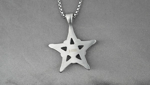Détail du marquage S-STEEL sur le pendentif pentagramme avec texture brossée