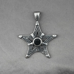 Pendentif étoile gothique en acier titane avec pierre noire sur fond en tissu gris