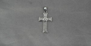 Detail of silver Celtic knot cross pendant featuring intricate metal texture and woven design