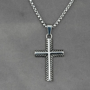 Vintage titanium steel cross necklace with box chain for men on textured grey fabric