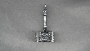 Dettaglio del ciondolo Mjölnir vintage con trama forgiata e motivi nordici