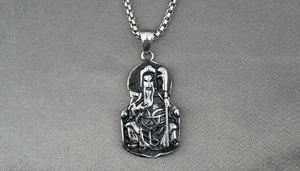 Macro detail of Guan Yu relief on a vintage stainless steel necklace with box chain
