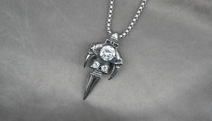Macro view of gothic skull pendant with dragon claws and a faceted zircon stone