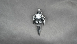 Macro detail of gothic skull and dagger pendant with sparkling clear crystal accents