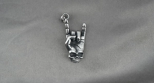 Détail du pendentif en acier inoxydable style punk avec geste rock et crâne
