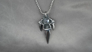 Detail of gothic skull pendant necklace with sharp claw design and sparkling zircon stone