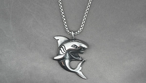 Detailed close-up of retro shark pendant with oxidized finish on vintage box chain
