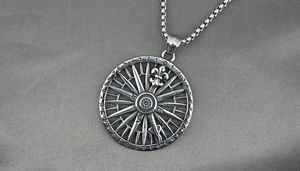 Macro shot of stainless steel compass pendant with numeric scales and iris detail