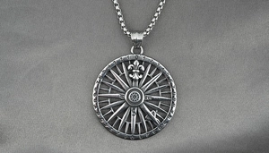 Macro detail of retro compass pendant with fleur-de-lis and vintage silver finish