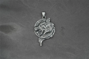 Detail eines Vintage-Wikinger-Wolfskopf-Anhängers mit oxidiertem Finish auf grauem Stoff