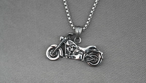 Détail d'un pendentif moto argenté avec texture mécanique rétro sur chaîne box