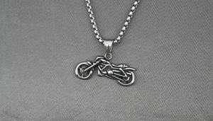 Détail macro d'un pendentif moto en argent rétro avec textures de moteur industriel