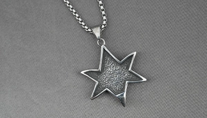 Détail du pendentif étoile en acier titane avec texture météorite et chaîne maille