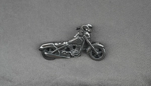 Gros plan du pendentif moto en acier titane avec finition rétro et détails du moteur